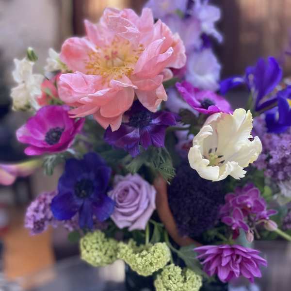 Bouquet of pink, purple, and white flowers with a large peach bloom