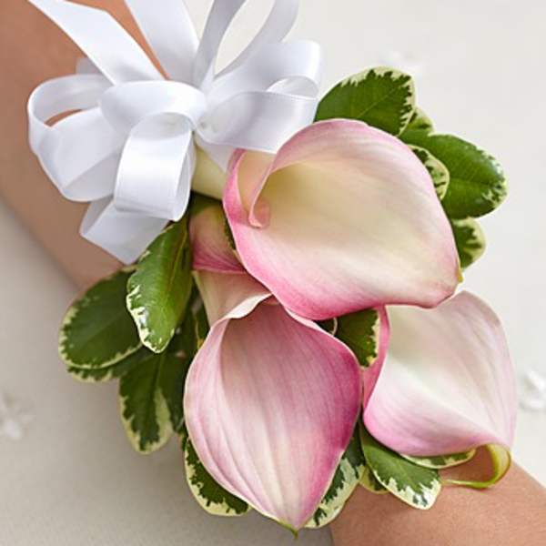 Pink and white calla lily wrist corsage with a white ribbon bow