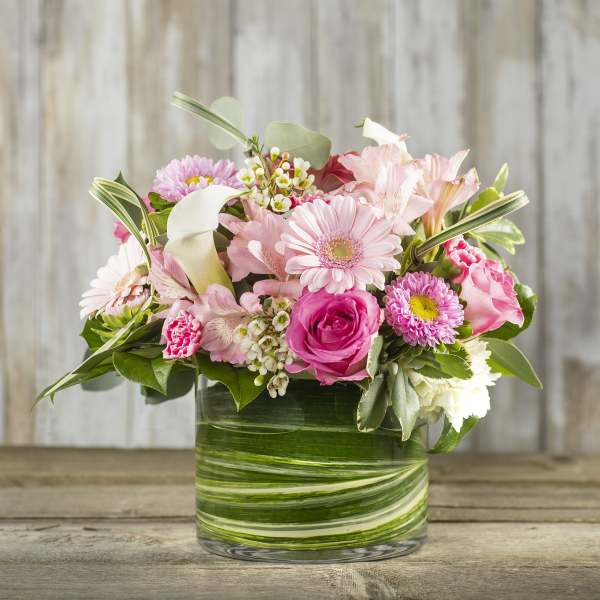 Pink mixed flowers arranged in a glass vase