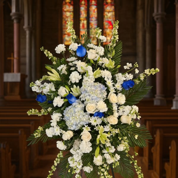 Large white and blue floral standing spray in a church