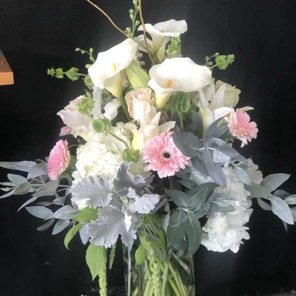 White calla lilies and pink gerbera daisies in a glass vase