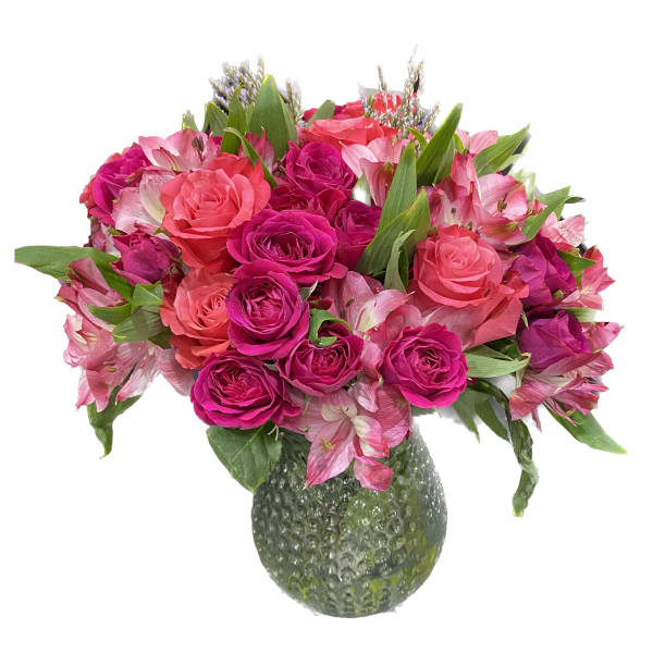 Pink and magenta roses with pink lilies in a textured glass vase