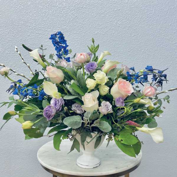 Mixed pastel bouquet in a white pedestal vase