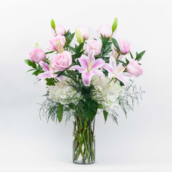 Pink roses and lilies in a clear glass vase