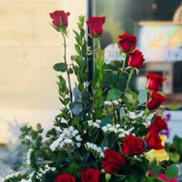 Tall arrangement of red roses with white accent flowers in a white wooden box
