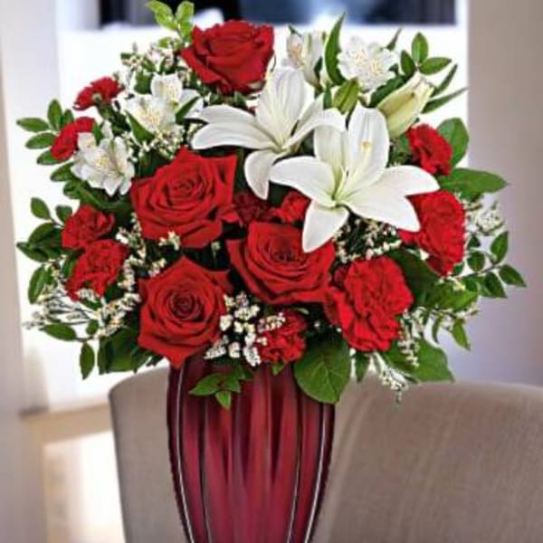 Red roses and white lilies arranged in a tall vase