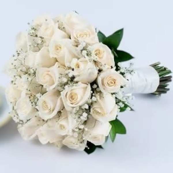 Hand-tied bouquet of white roses and baby's breath wrapped in white ribbon