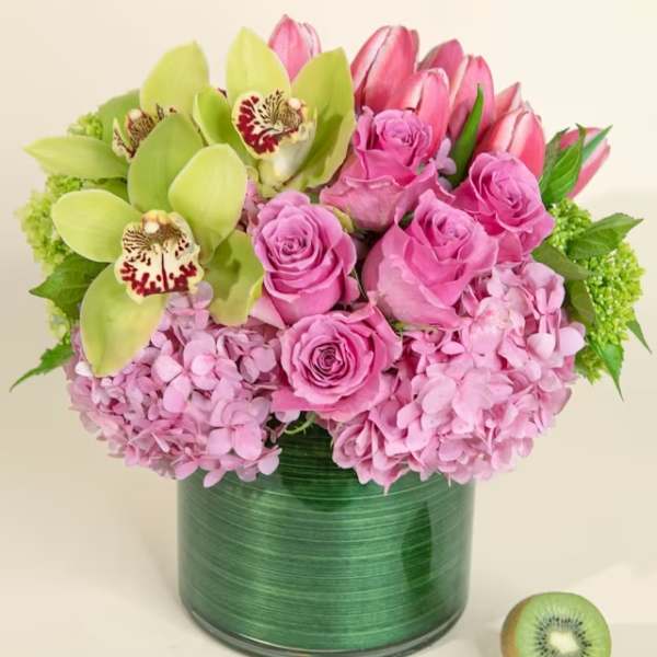 Pink roses and hydrangeas with green orchids in a green vase