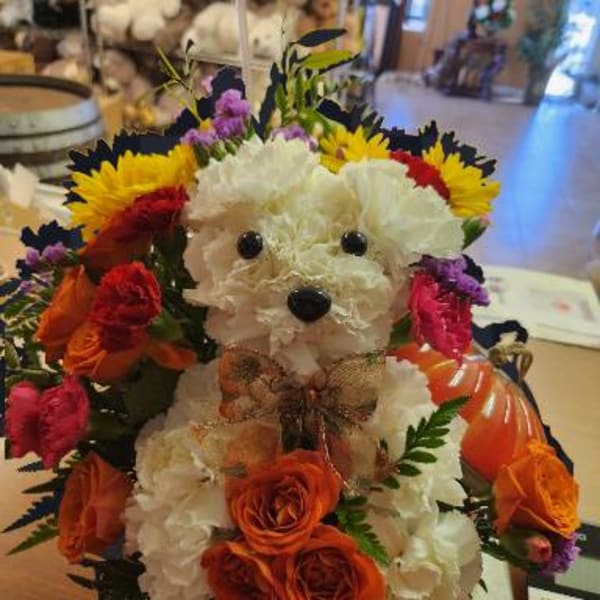 Flower arrangement shaped like a teddy bear with a bow