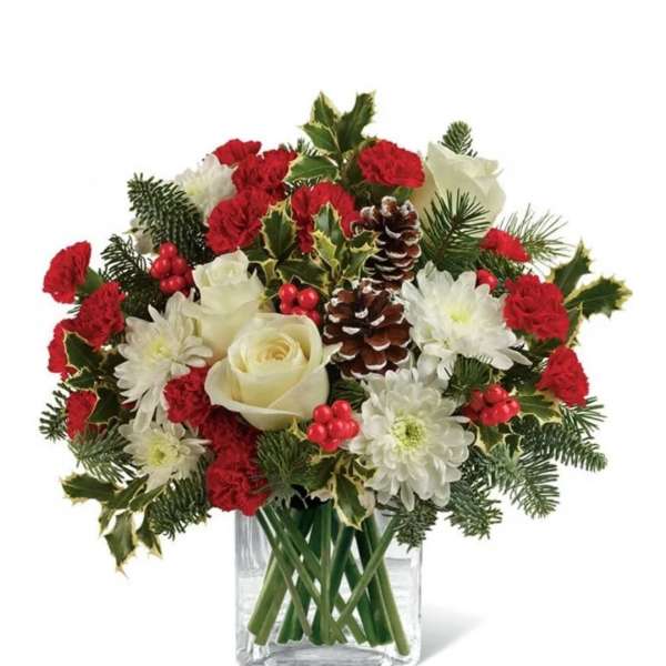 Holiday bouquet of red carnations, white roses, and chrysanthemums in a glass vase