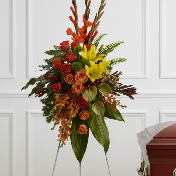 Standing floral spray with red, orange, and yellow flowers on an easel