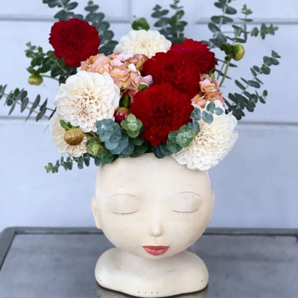 Flower crown of red, white, and peach blooms on a mannequin head