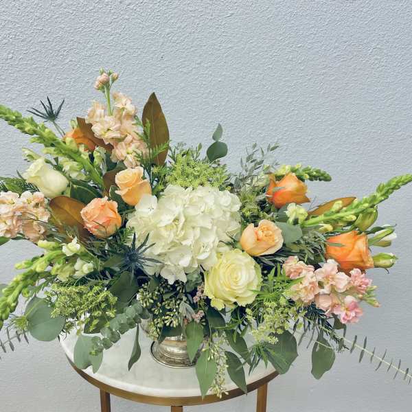 Mixed floral arrangement with peach roses and white hydrangea in a vase