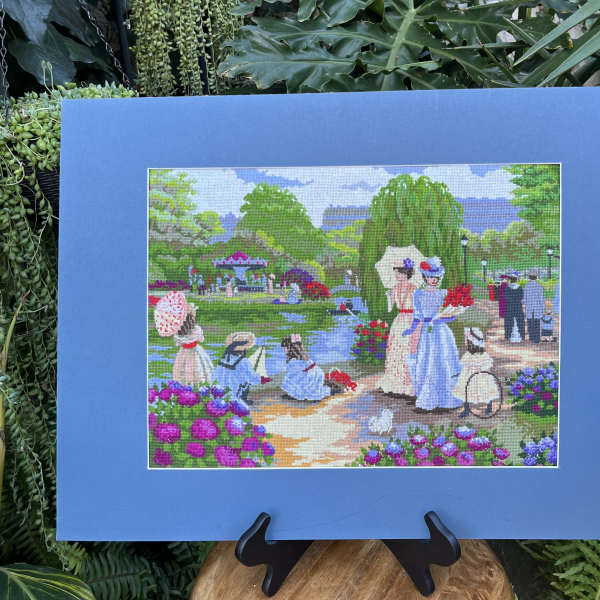 Blue-framed artwork showing women in a flower garden