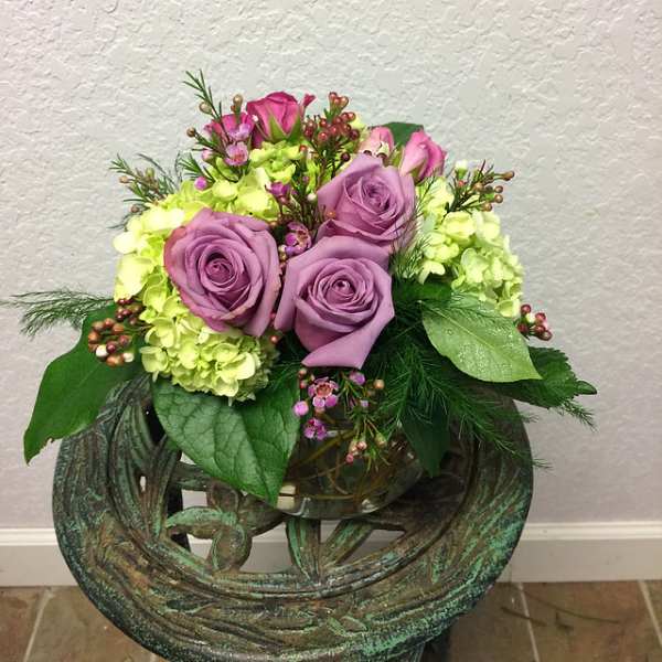 Lavender roses and lime hydrangeas in a glass vase