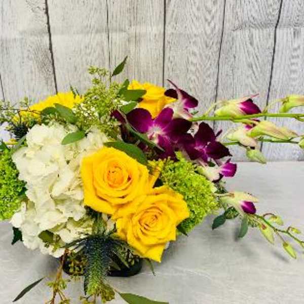 Bouquet of yellow roses, white hydrangeas, and purple orchids