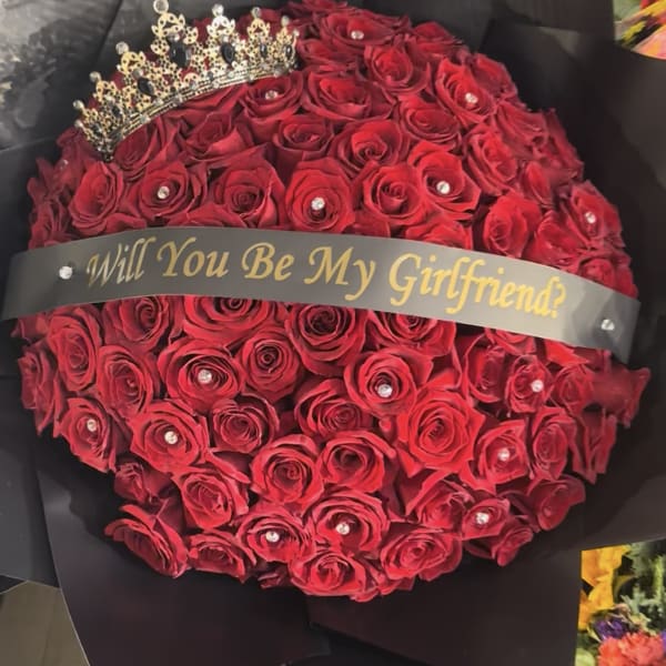 Red rose bouquet with a tiara and "Will You Be My Girlfriend?" ribbon