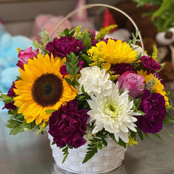 Basket arrangement with sunflowers, roses, chrysanthemums, and carnations
