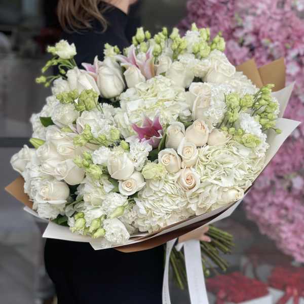 Large bouquet of white roses, hydrangeas, and lilies with pink accents