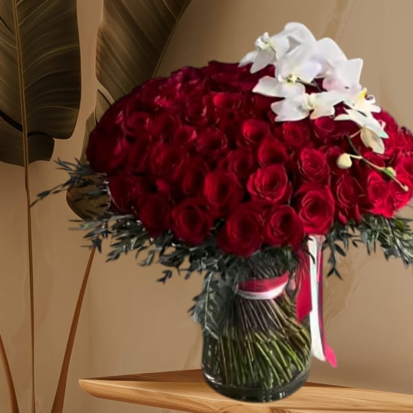 Large bouquet of red roses with white orchids in a glass vase