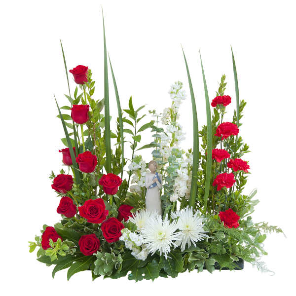 Red roses, red carnations, and white mums with a small figurine in a low arrangement with tall green blades