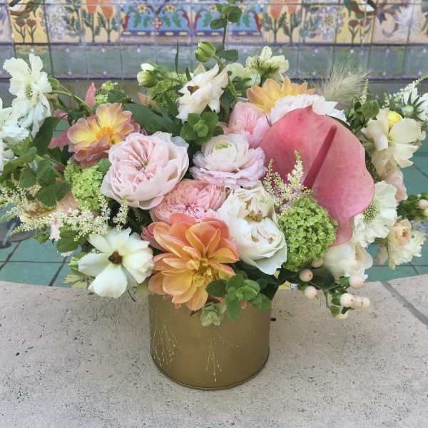 Mixed pastel flower arrangement in a gold vase