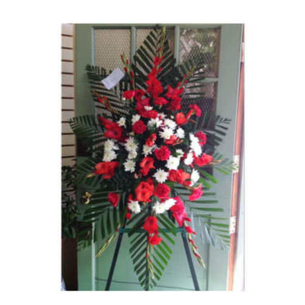 Standing floral spray with red and white flowers on an easel