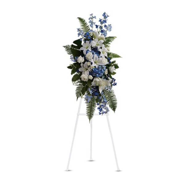Tall white and blue floral standing spray on an easel