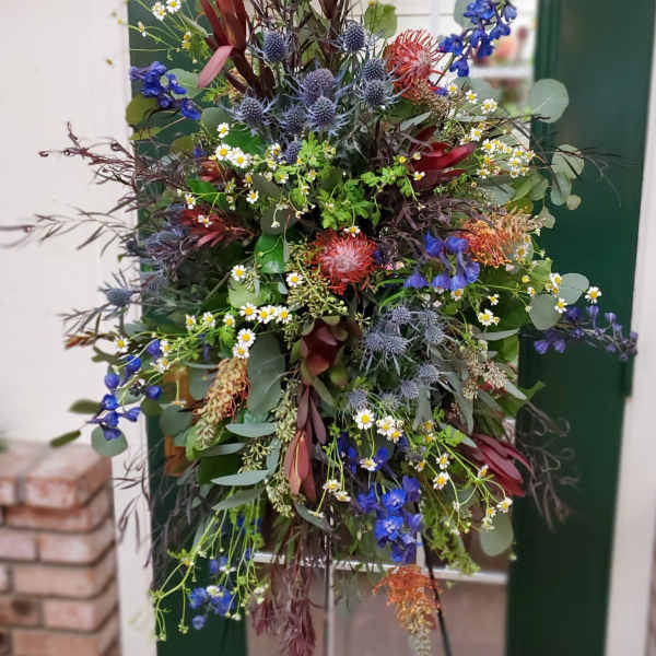 Large mixed floral arrangement with blue, red, and white blooms