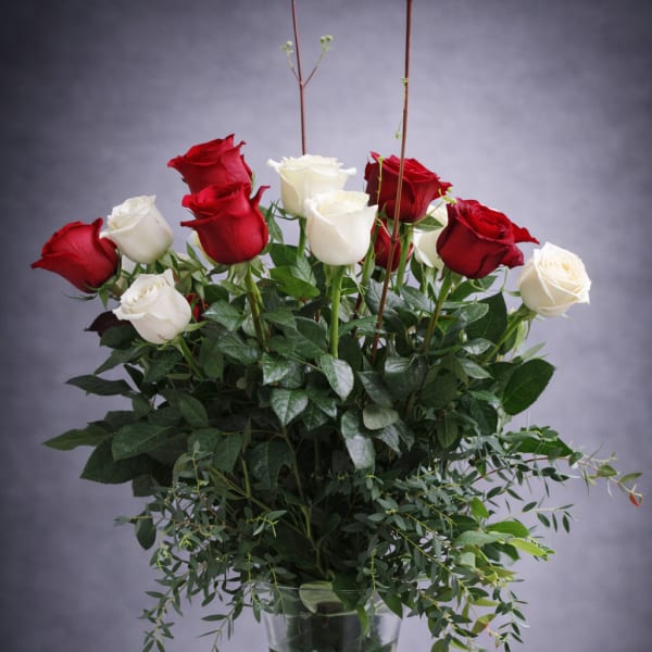 Red and white roses in a tall glass vase