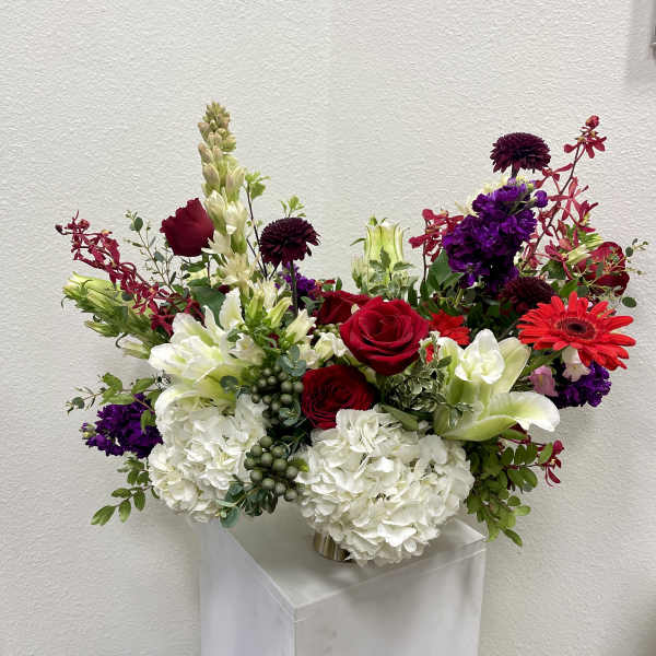 Mixed bouquet of red, white, and purple flowers in a vase