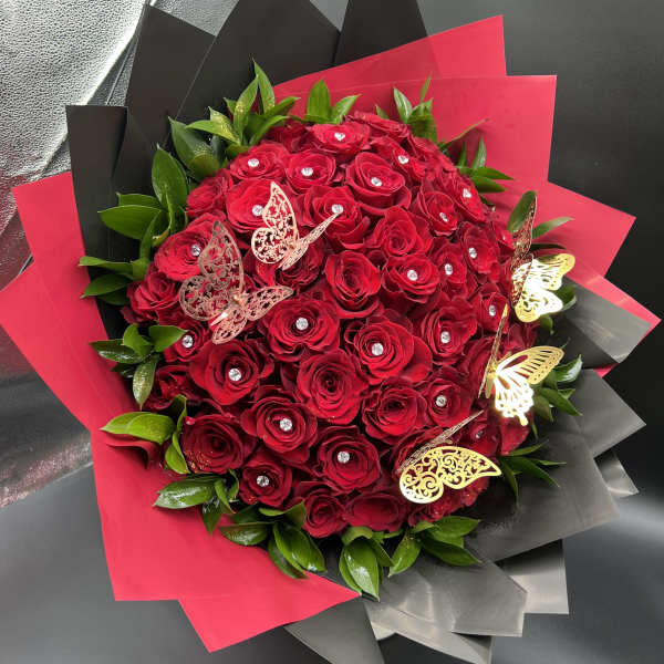 Large bouquet of red roses with crystal centers wrapped in red and black paper with gold butterflies