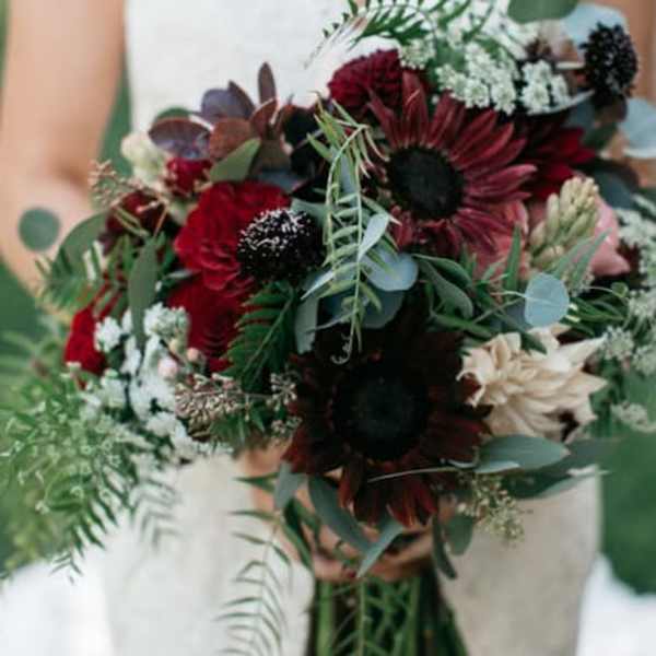Bouquet of dark red and cream flowers with greenery