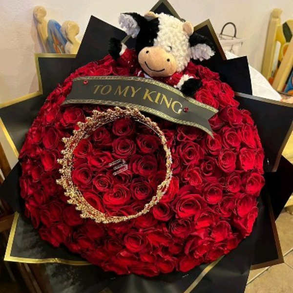 Large red rose bouquet with a plush cow and a "TO MY KING" ribbon