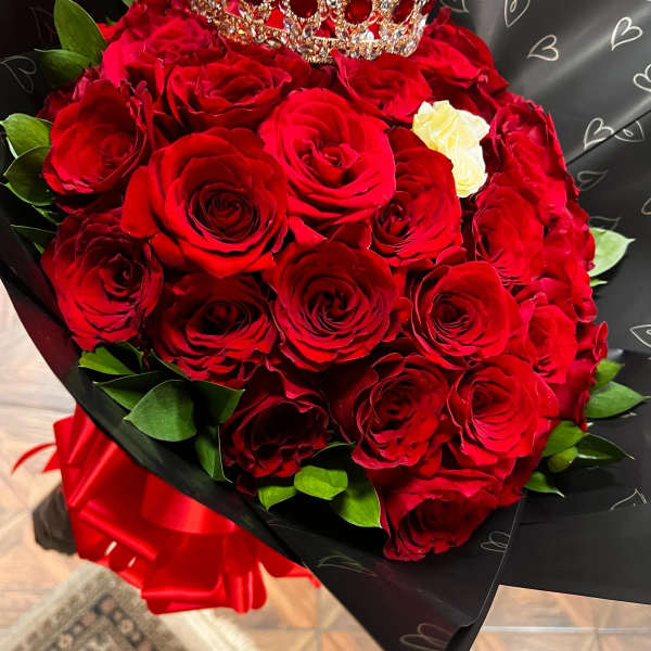 Bouquet of red roses with a jeweled crown on top
