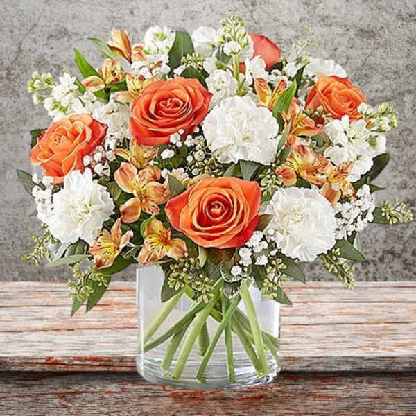 Bouquet of orange and white flowers in a clear glass vase
