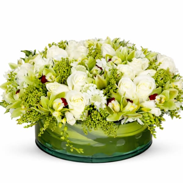 White and green floral arrangement in a low glass bowl