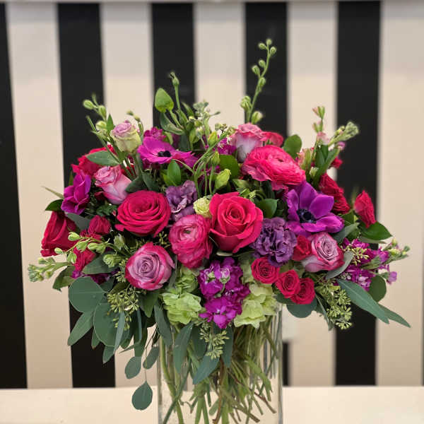 Pink and purple mixed flower arrangement in a clear glass vase