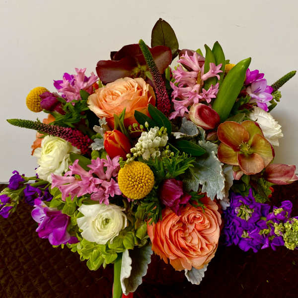 Colorful mixed bouquet with peach roses, pink blooms, and purple flowers