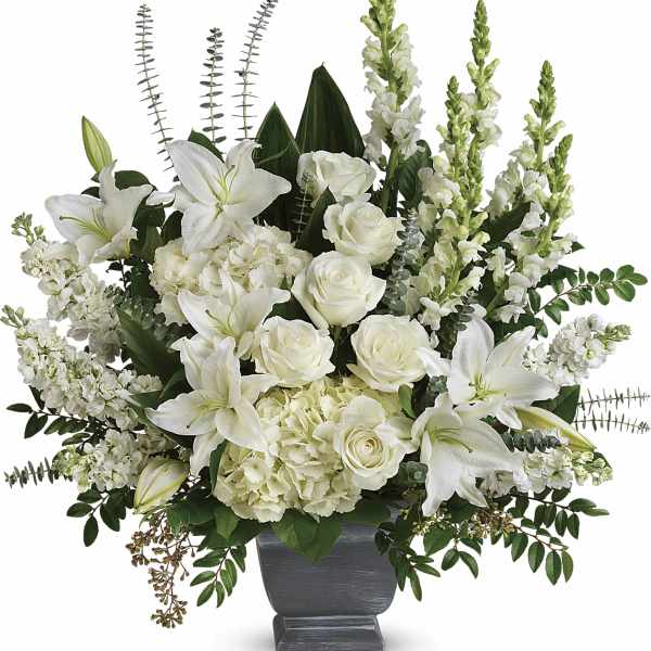 White lilies and roses arranged in a dark vase