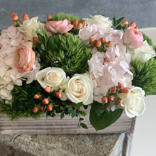 Pink and white floral arrangement in a wooden box