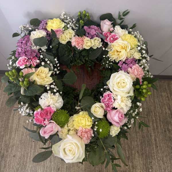 Heart-shaped floral wreath with pink, yellow, and white flowers