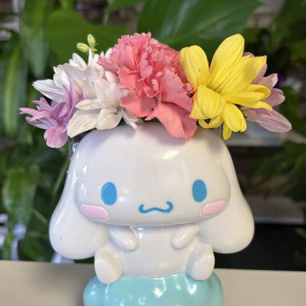 Small flower arrangement in a white cartoon dog planter