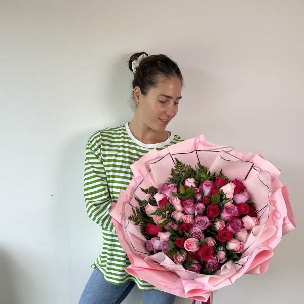 Large bouquet of pink and red roses wrapped in pink paper