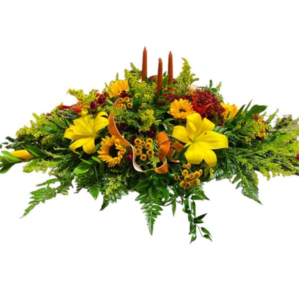 Low floral casket spray with yellow blooms and greenery