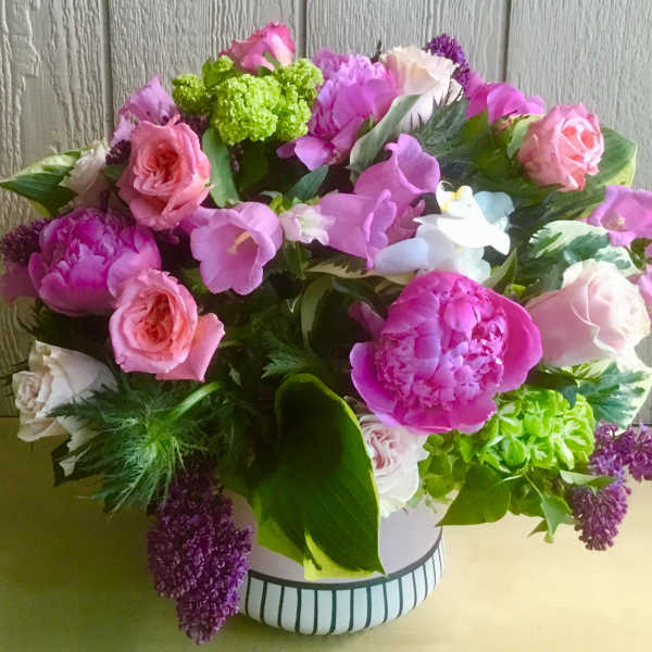 Pink and purple mixed bouquet in a striped white vase
