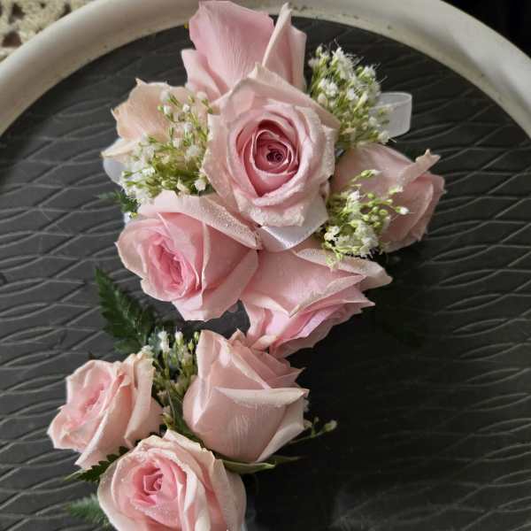 Pink rose boutonniere with small white filler flowers