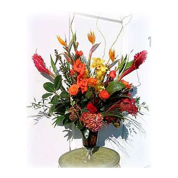 Tall tropical flower arrangement in a glass vase