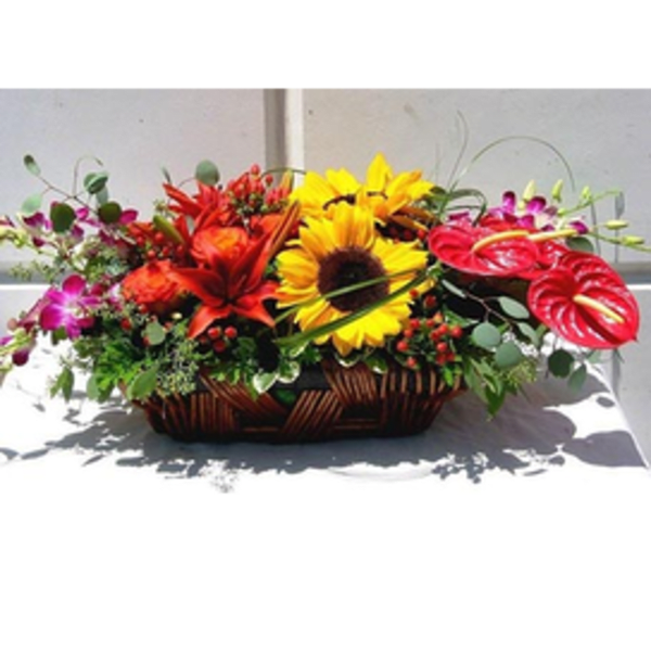 Basket arrangement with sunflowers, red lilies, and pink anthuriums