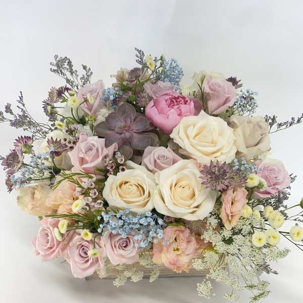 Pastel rose bouquet with a succulent in a wooden box